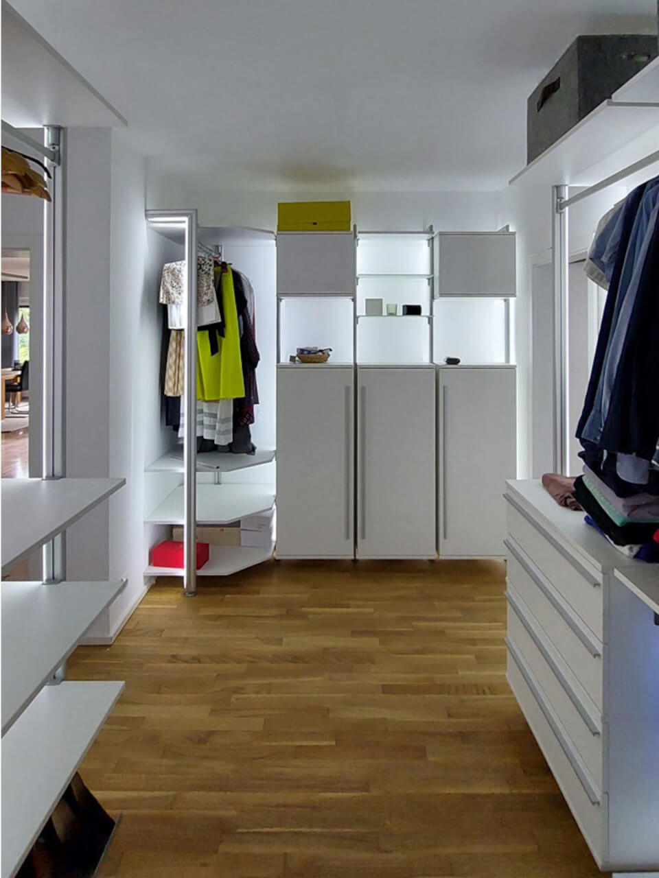 Offenes Schranksystem mit Hängefläche, Holzfußboden und Schubladen im begehbaren Kleiderschrank