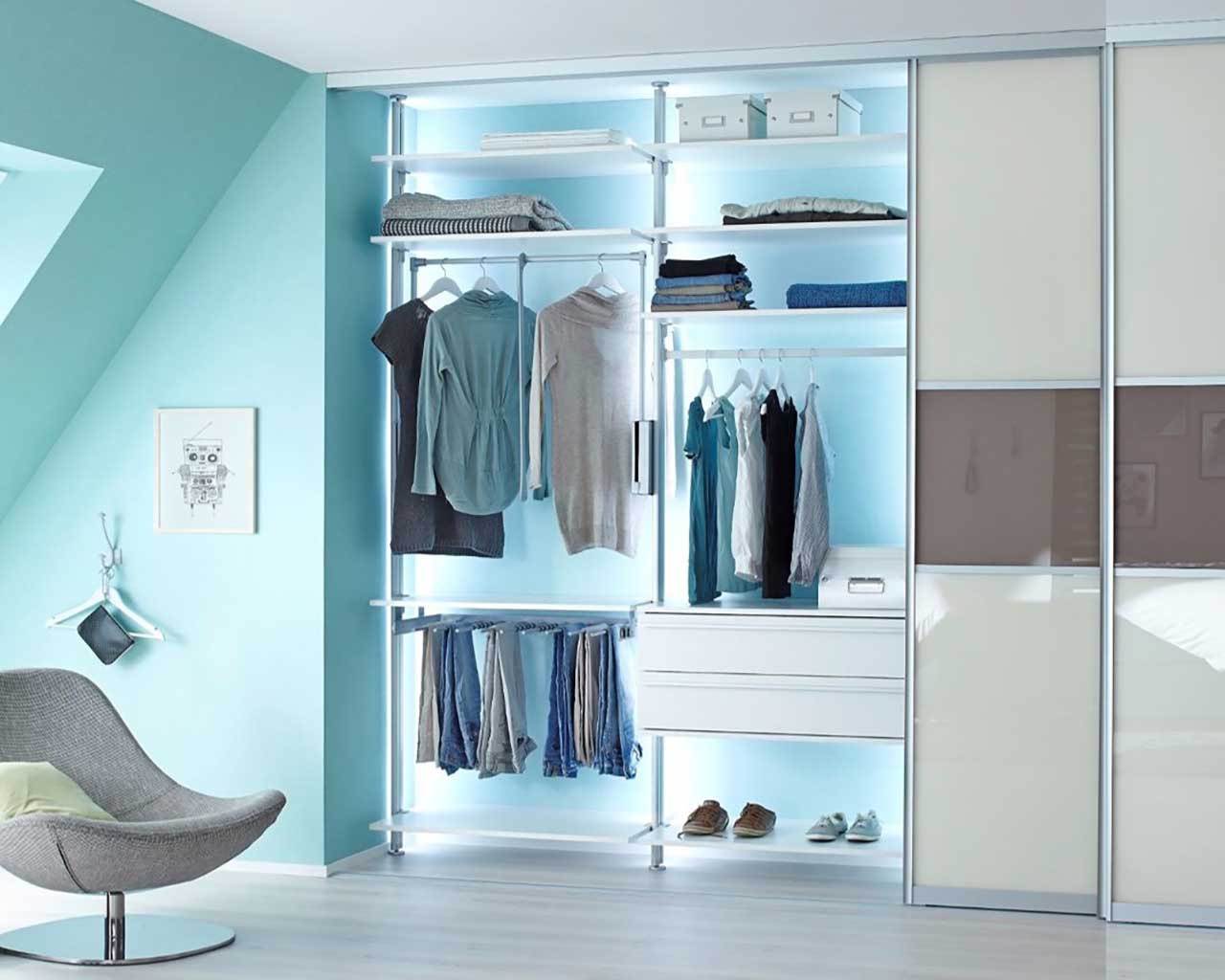 Elegantes Schlafzimmer mit einem offenen Kleiderschrank mit Hosenhalter, Schubladen, Kleiderstangen und Beleuchtung im Schrank, optional mit Schiebetüren, einem komfortablen Stuhl, perfekt für moderne Wohnräume.